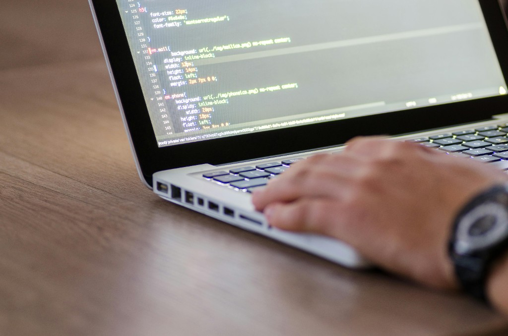 Developer working on a laptop with code editor open on screen